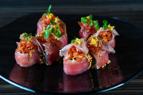 Spicy tuna and prosciutto sushi rolls with bubu arare spherical rice crackers, avocado, tomato relish, and bottarga from high end Bellevue sushi bar