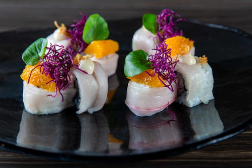 Hamachi truffle sushi rolls with orange, Okinawa sweet potato, shaved truffle, and truffle aioli