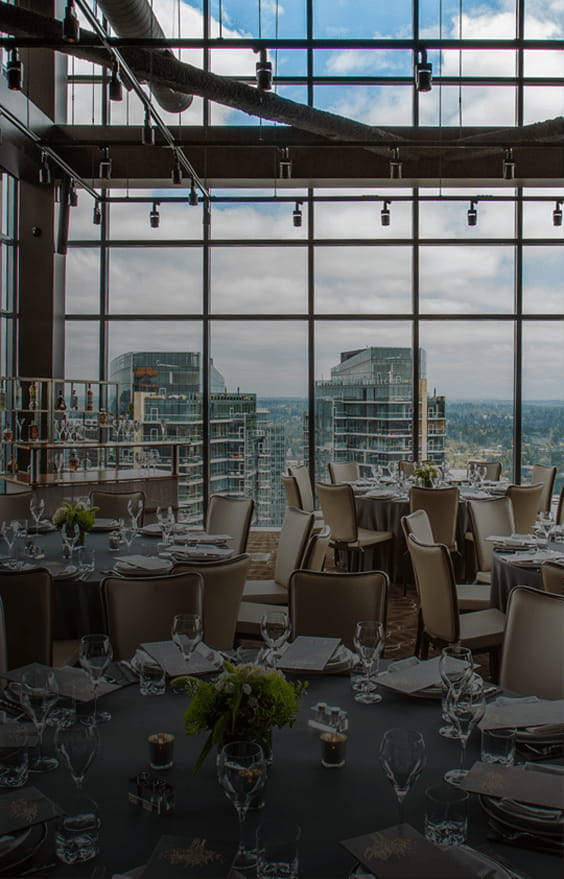 Private dining room at Bellevue steakhouse with large, elegant tables and view of city for private events