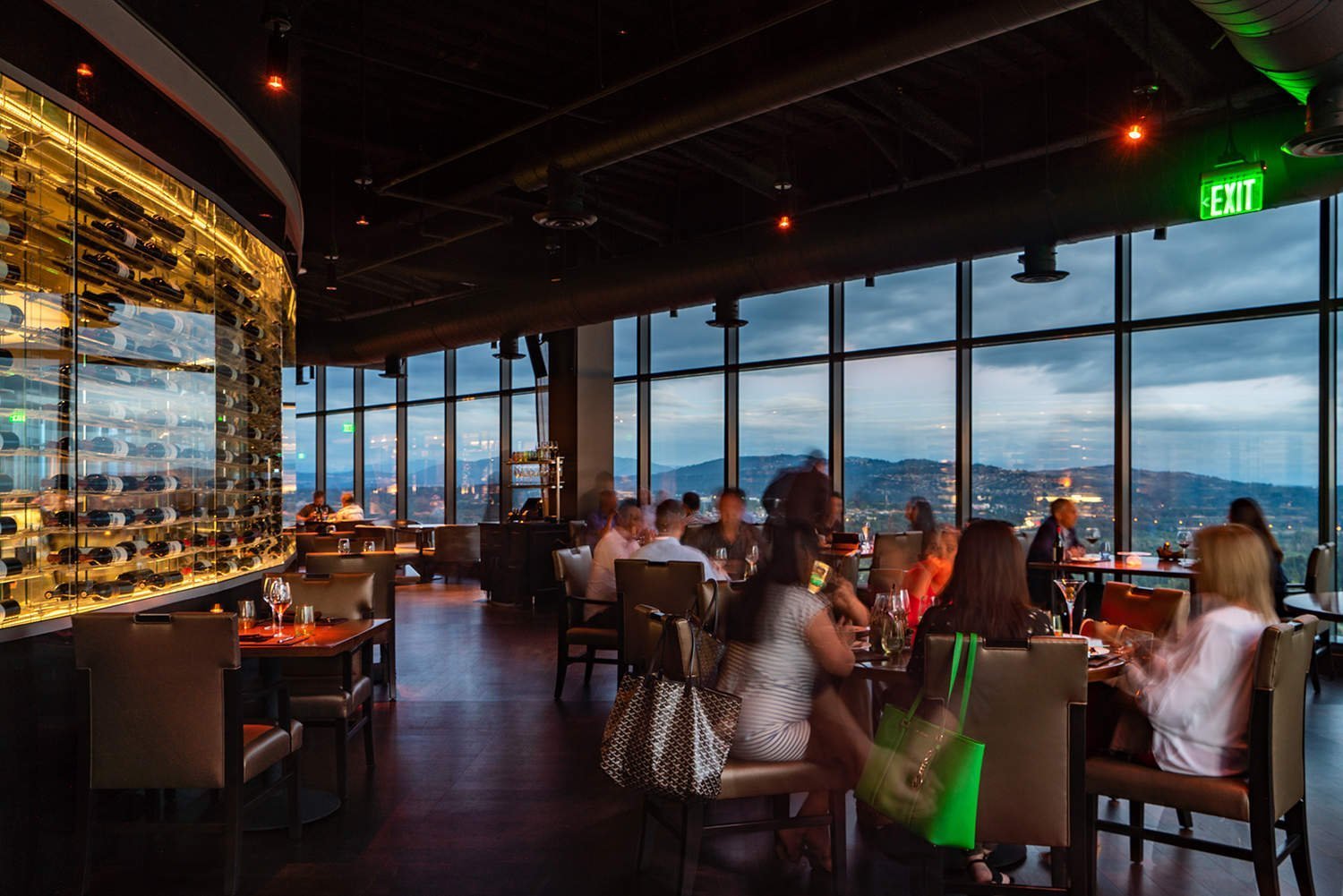 Bellevue fine dining restaurant with wine display and patrons enjoying drinks with view from 31st floor