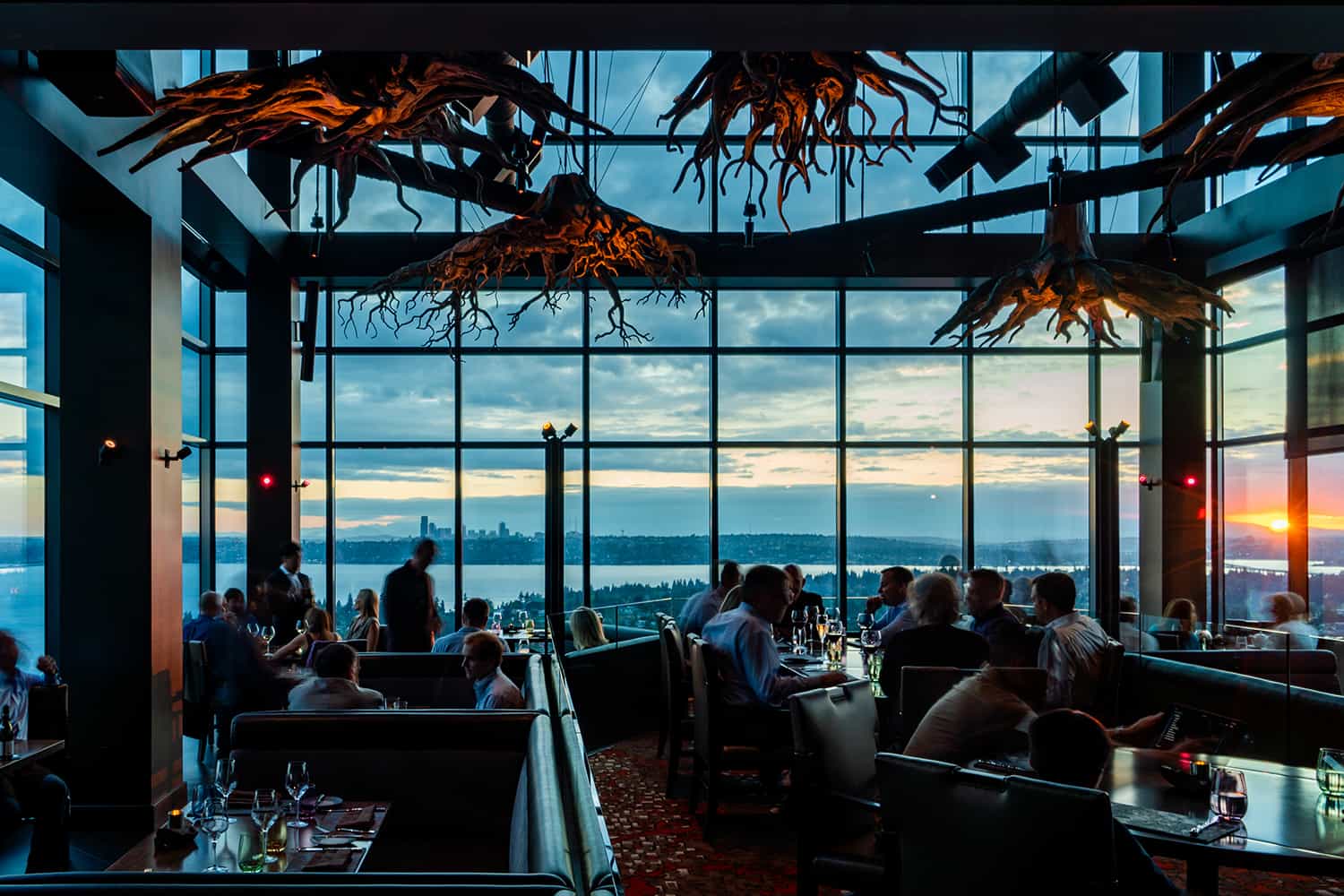 Bellevue steakhouse overlooking bay at sunset with patrons enjoying wine and attentive service