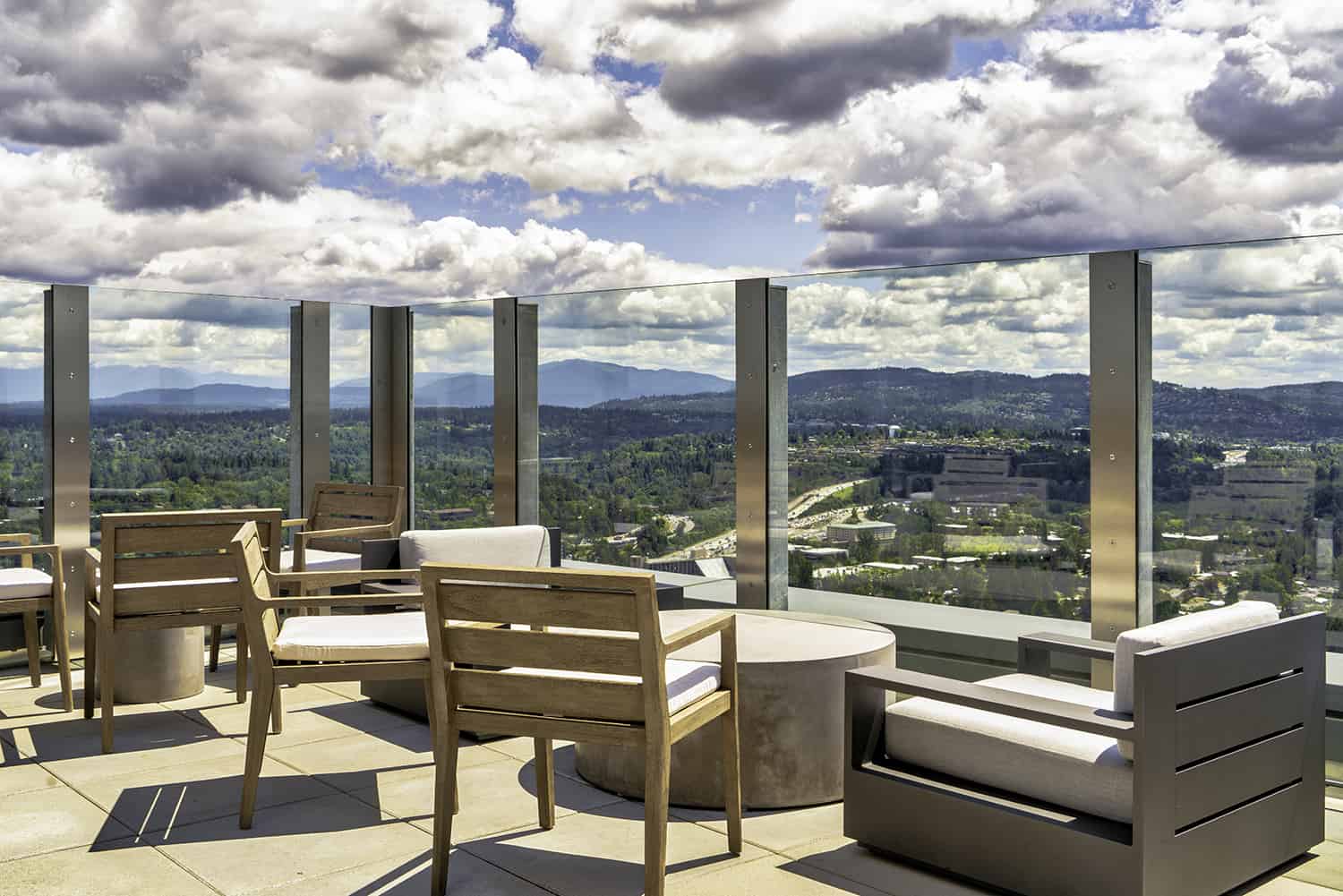 Rooftop seating in Bellevue steakhouse with lounge chairs, view of wilderness, and open air