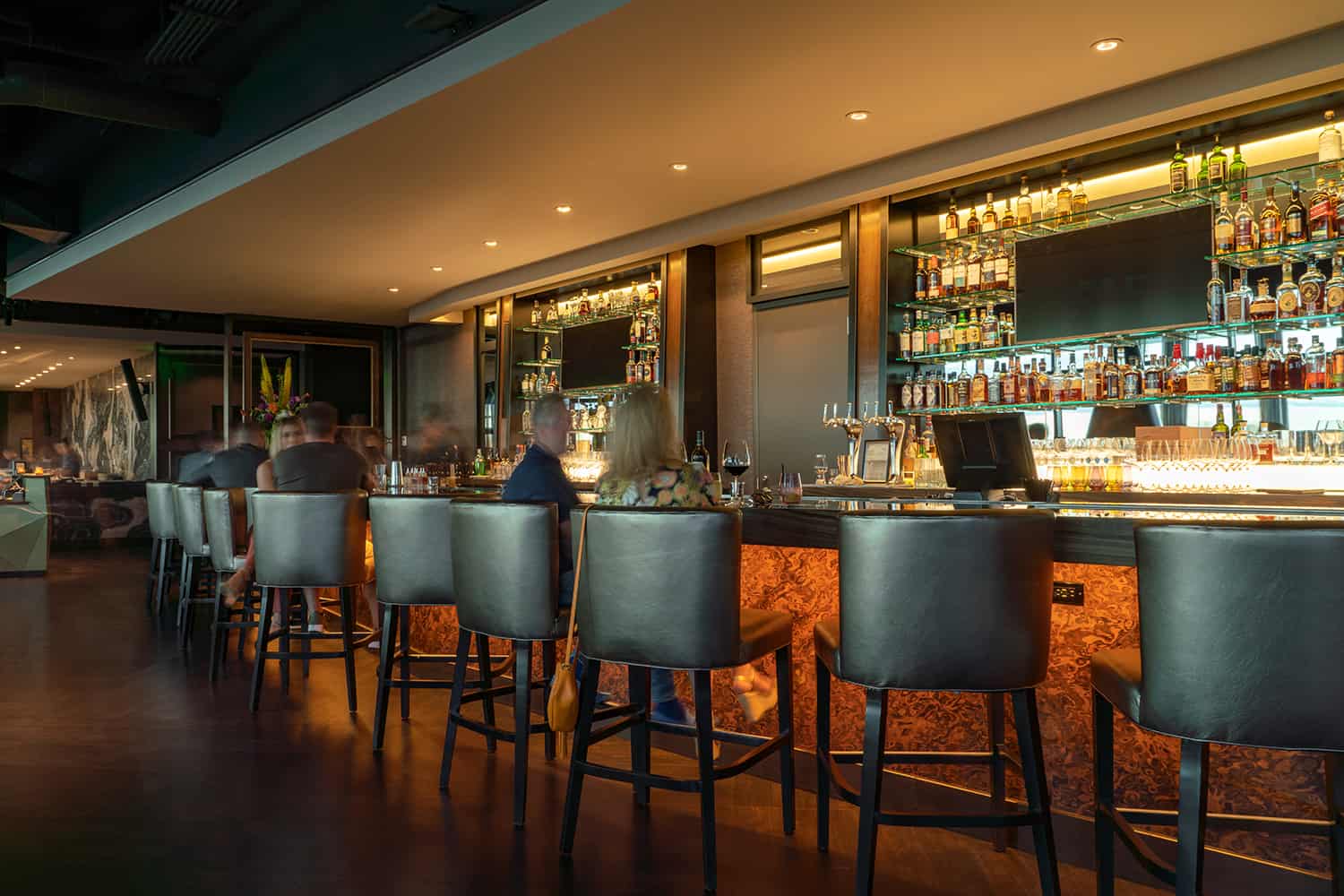 Full bar in Bellevue steakhouse with patrons enjoying wine, beer, and cocktails