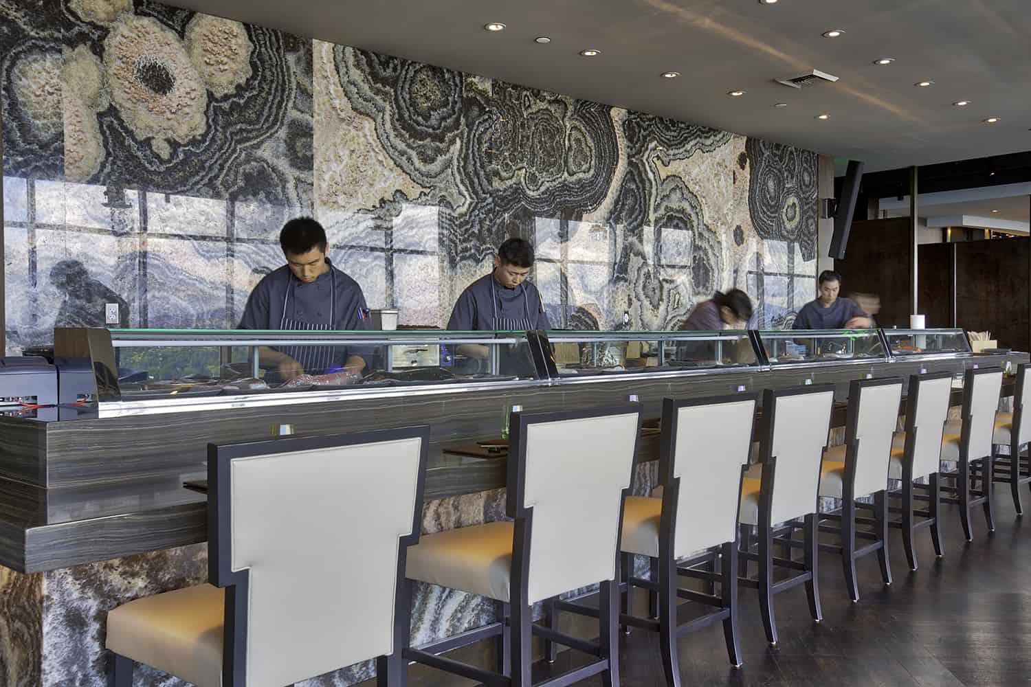 sushi chefs preparing high end seafood dishes in Bellevue rooftop restaurant with seating by counter for fresh sushi