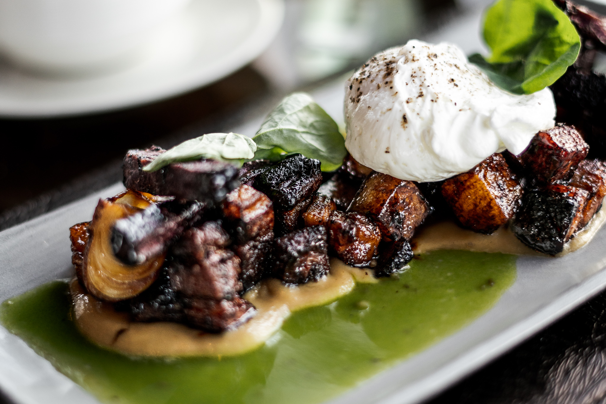 Pork belly and ube potato hash with poached eggs from Bellevue fine dining brunch