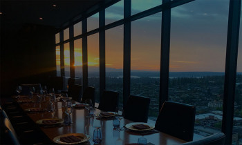 Private dining suite at Bellevue steakhouse with sunset view from long table for big events